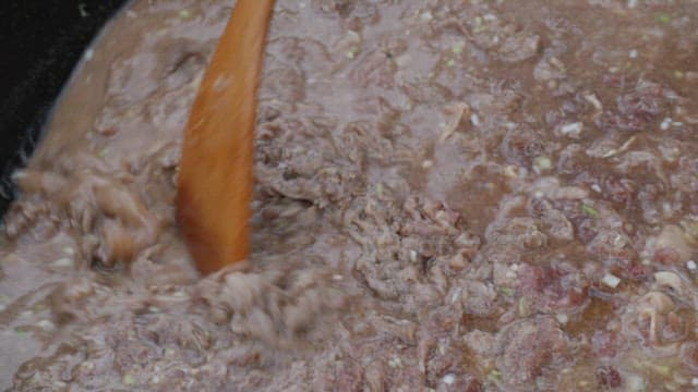 Cooking beef bulgogi with a spatula in a frying pan