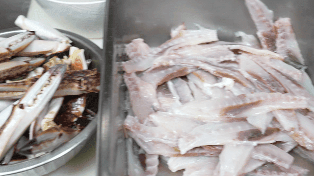 Fresh crab claws and fish fillets in trays