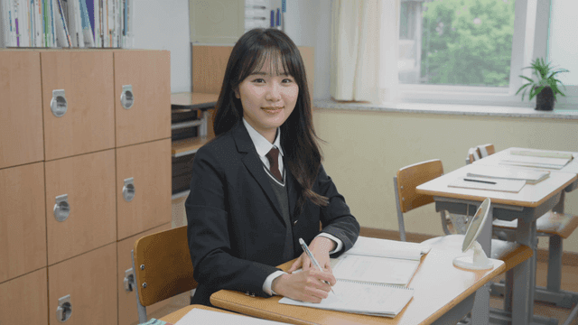 Female student smiling while sitting in the classroom