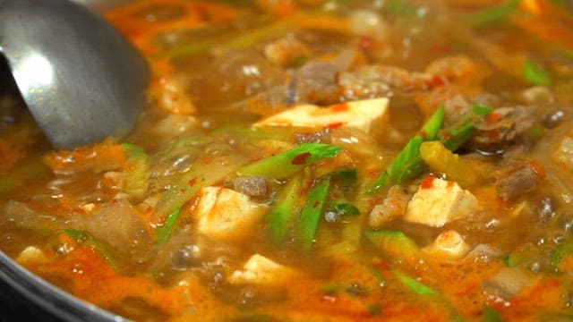채소와 고기가 듬뿍 들어간 찌개가 끓고 있는 모습