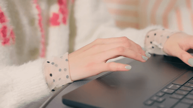 Hands typing on a laptop keyboard