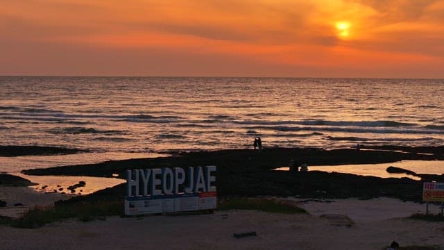 Sunset at Hyeopjae Beach with people