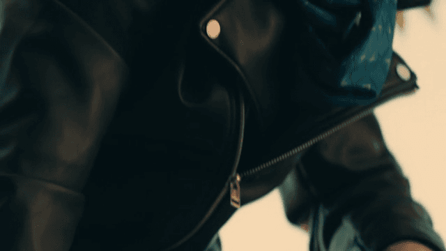 울타리를 잡고 있는 가죽 재킷을 입은 사람