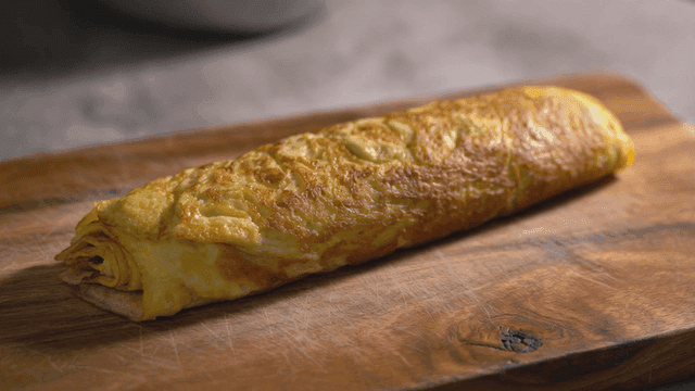 Rolled omelet on wooden cutting board