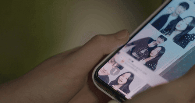 커플 사진으로 된 스마트폰을 들고 있는 사람