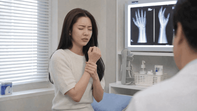 Woman holding her wrist at clinic