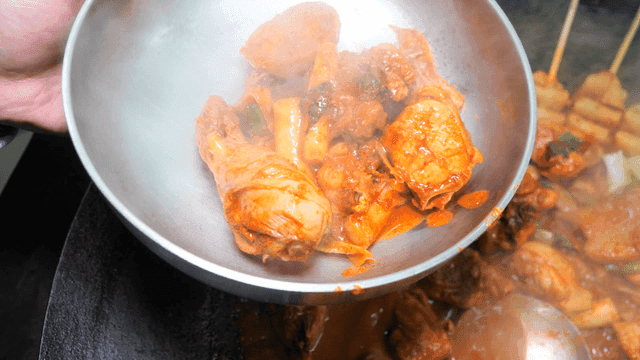 Ladle for serving spicy chicken stew into bowl