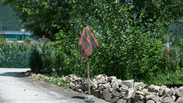 풍성한 잎과 돌길에 있는 천이 올려진 조각품