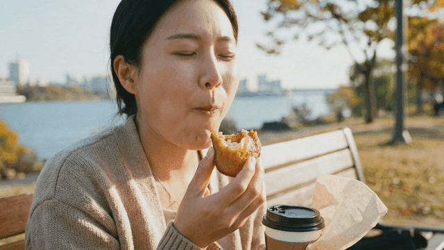 Woman eating butter rice cakes by river