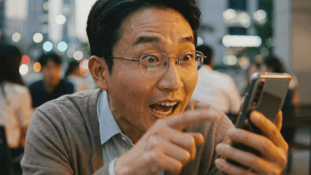 Man smiling while using a smartphone