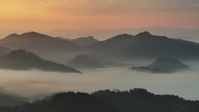 Sky Colored by Sunrise over Foggy Mountains