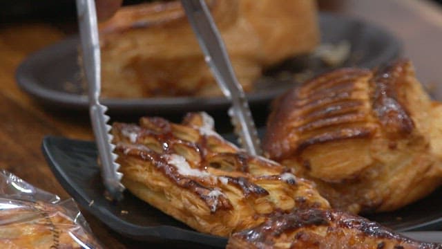 Freshly baked apple pie cut into bite-size pieces with tongs and scissors