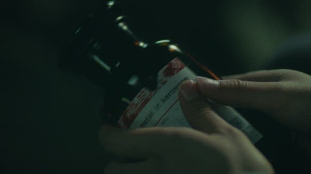 밤에 소디움메탈이 들어 있는 유리병을 확인하는 손