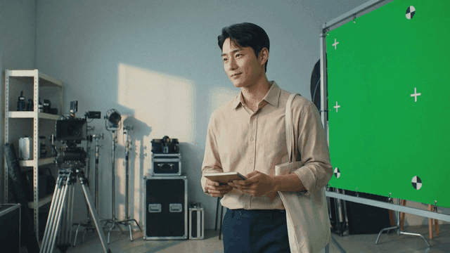 Man in studio with green screen filming equipment