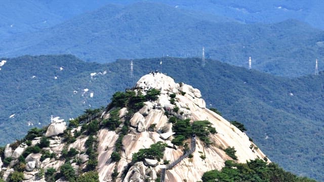 Buramsan mountain peak with hikers and lush greenery