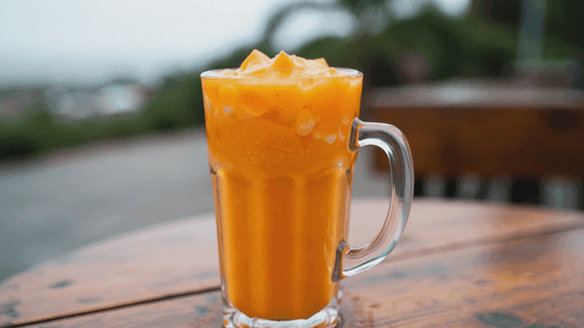 나무 테이블 위의 오렌지 스무디 한 잔