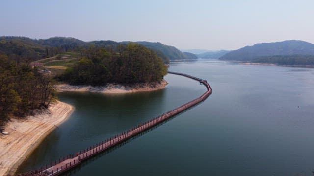 Serene lake with a long wooden bridge