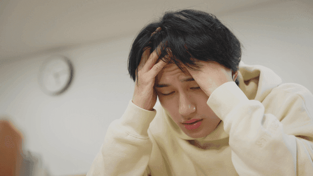 머리를 감싸며 스트레스를 받는 남성