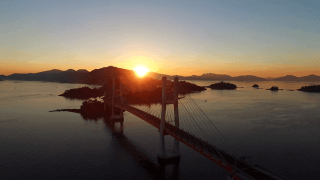 Sunrise over a bridge and calm sea