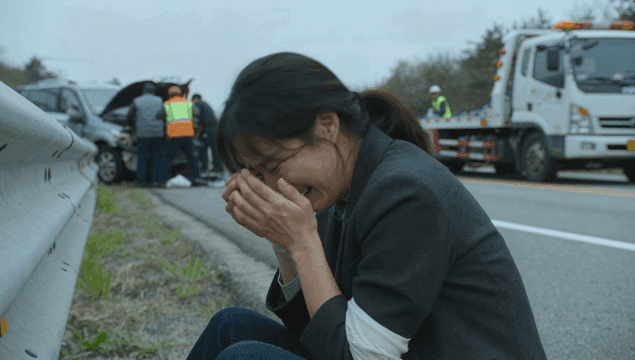 Woman crying by a car accident scene