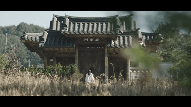 고요한 들판의 한옥을 들어가는 여성