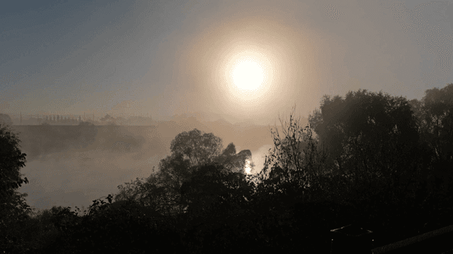 Sunrise over a misty river landscape