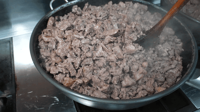 Spatula stir-frying beef in large pot