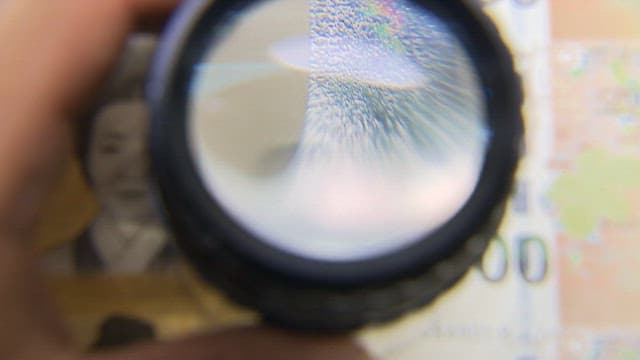 Design elements to prevent counterfeiting through a magnifying glass