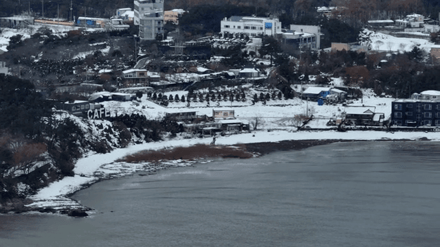 건물들이 있는 눈 덮인 해안 마을