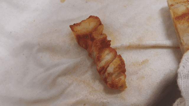 Gloved hand painting model of pork belly on canvas with brush