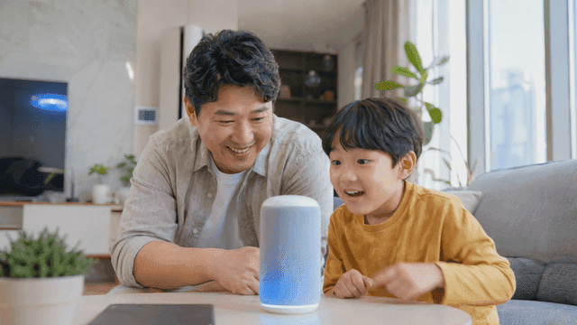 스마트 스피커와 상호작용하는 아버지와 아들