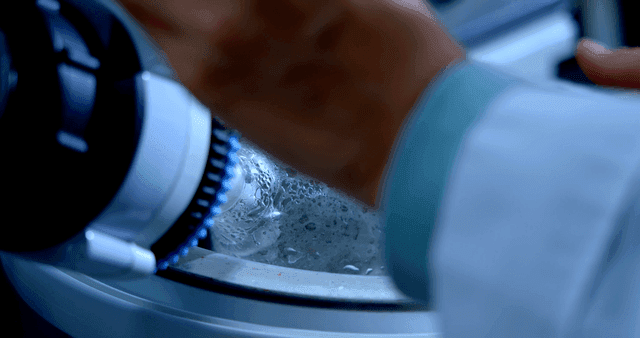 액체가 든 플라스크를 회전시키는 기계를 다루는 과학자