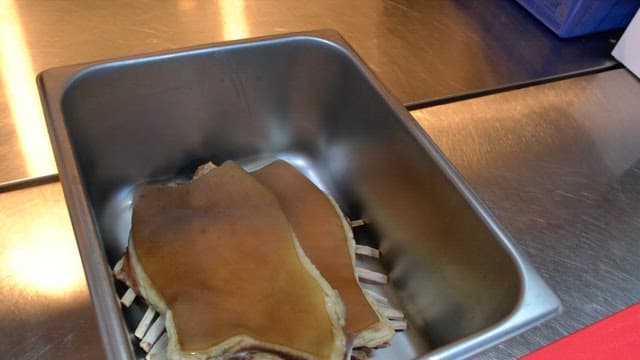 주방의 금속 용기 안에 담겨 있는 고기 수육