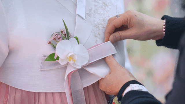 Adjusting a ribbon on a traditional hanbok