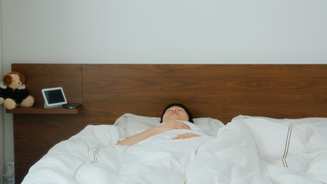 Man waking up and checking phone in bed