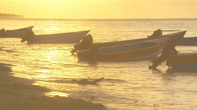 Boats on a tranquil sea at sunset