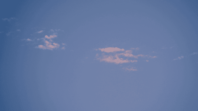 Clear blue sky with scattered clouds