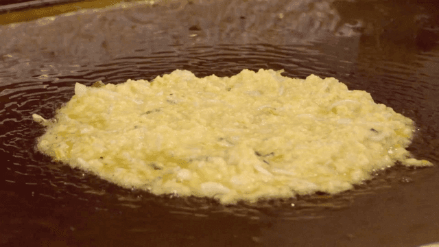 Mung bean pancake batter cooking in pan