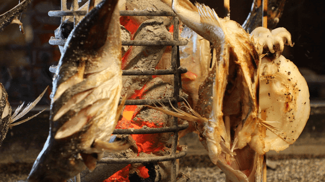 Primitive grilled fish skewers cooked next to charcoal