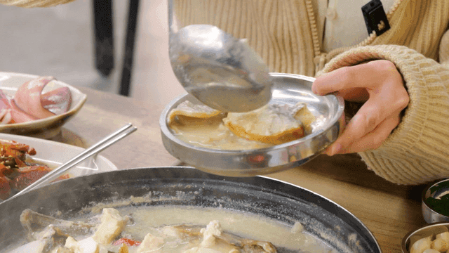 Person serving rockfish fermented fish sauce onto plate