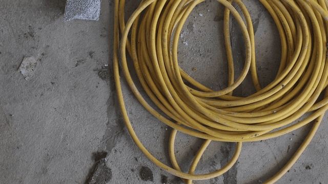 콘크리트 바닥에 감긴 노란 케이블