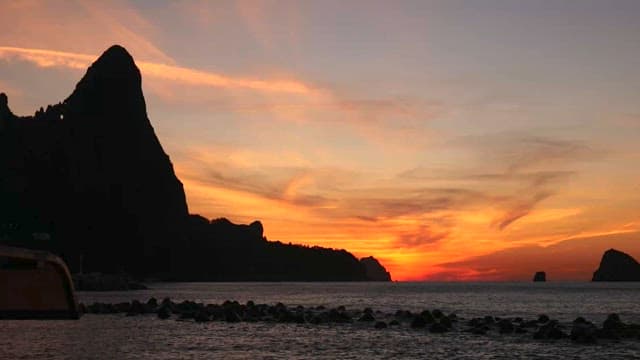 Sunset Over Sea with Silhouetted Cliffs