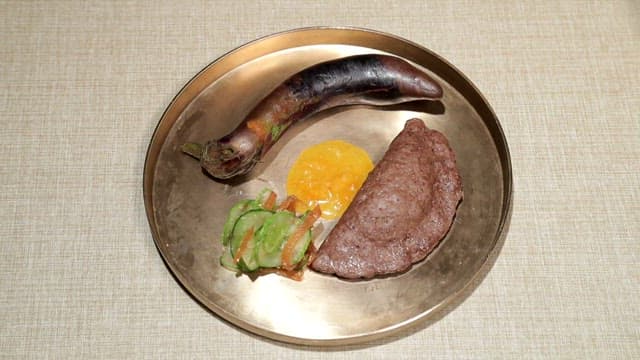 놋쇠 접시에 담긴 육만두와 구운 가지