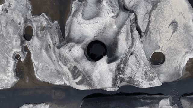 Rock with round hole in flowing river