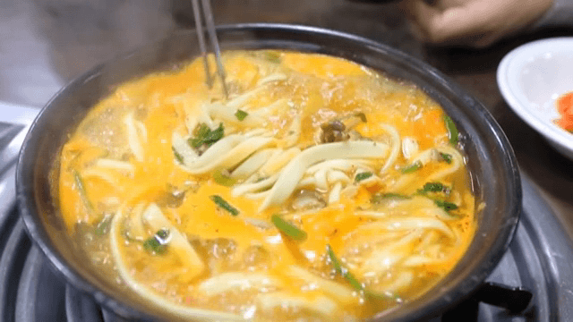 냄비에서 끓고 있는 버섯 칼국수
