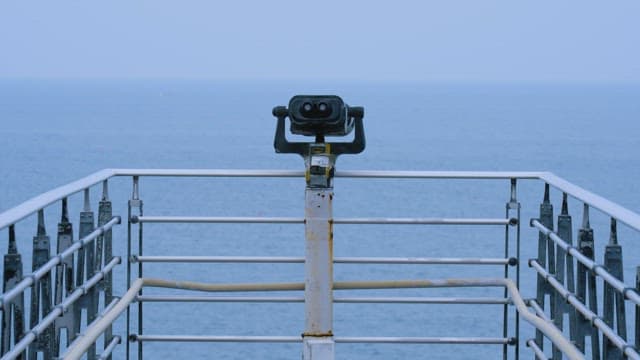 Man Looking Down at the Calm Sea from a Deck