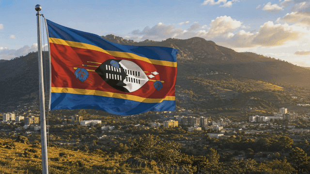 Eswatini flag fluttering against mountain backdrop