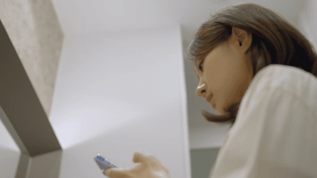 화장실에서 거울을 보며 머리를 정리하는 여성