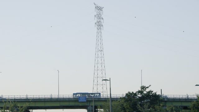 Busy Overpass and Electrical Tower during Daytime