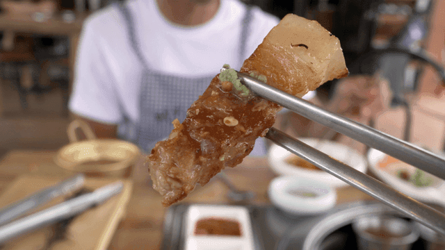 Grilled pork belly with wasabi, picked up with chopsticks